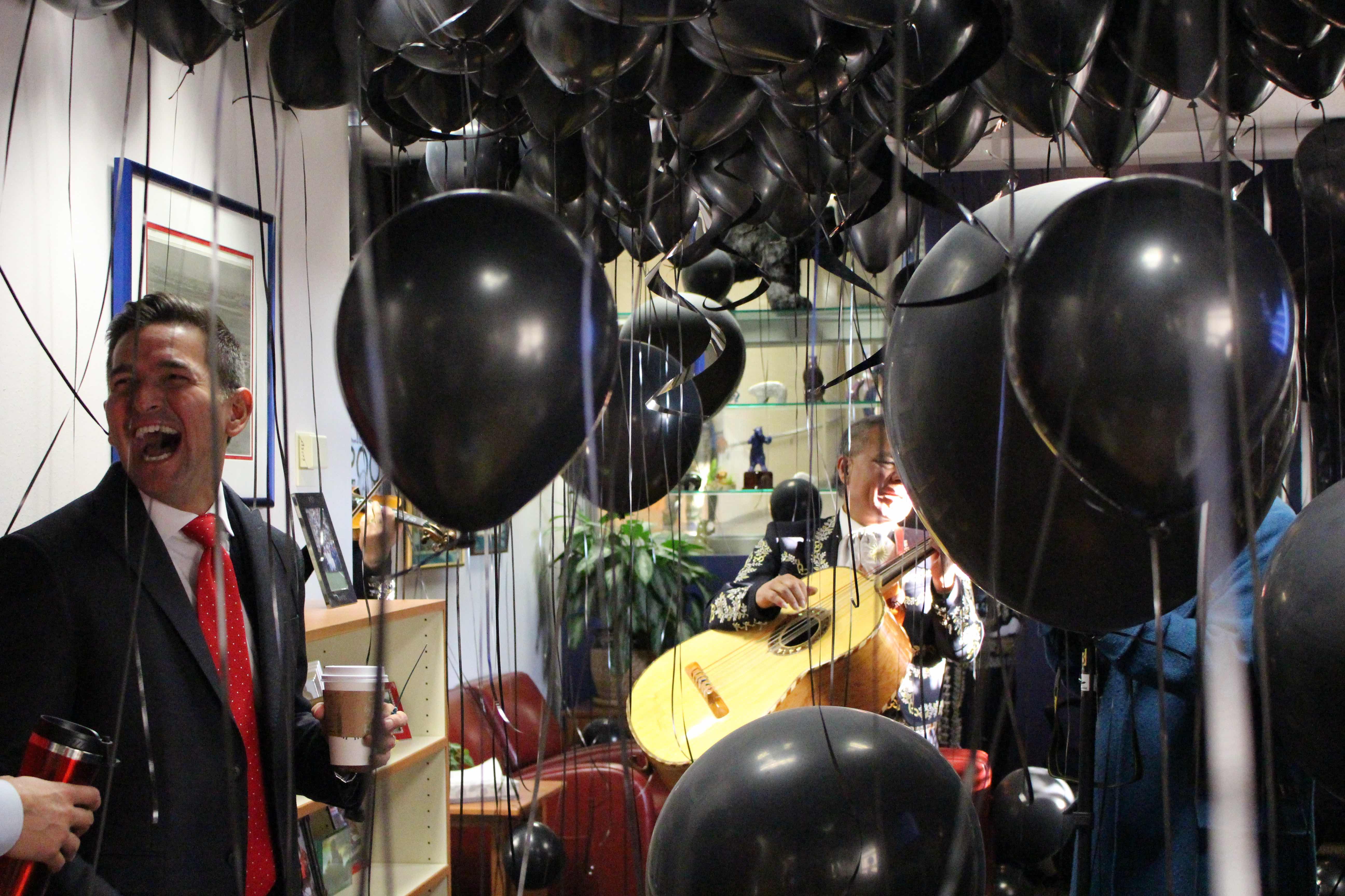 Principal Silva is surprised in his office by balloons and a mariachi band.