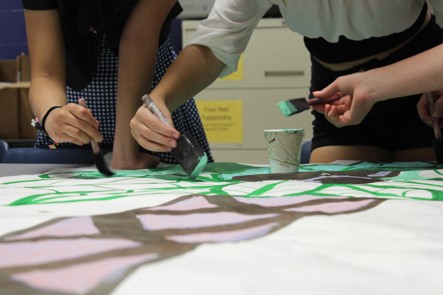 Student Senate decorates posters for the Homecoming Dance. They hope to make the gym feel like a music festival.