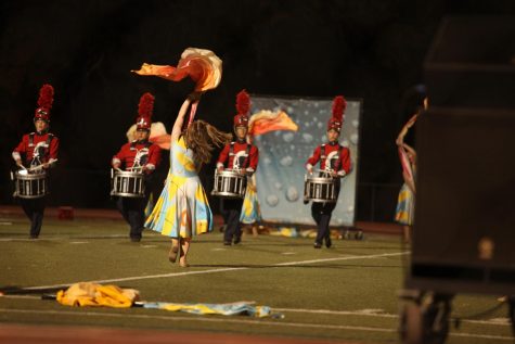 Junior Tori Lashbrook spins a flag during Creeks regional state qualifier. One of the most tenured members of marching band, Lashbrook has been on color guard since 2018, when she was in seventh grade. She is now the junior color guard captain. “It’s just like a big family that all works hard,” Lashbrook said of the color guard, who accompanies the band with elaborate dance routines.