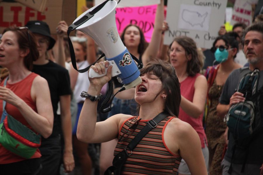 A+protester+shouts+call-and-response+chants+into+a+megaphone+near+the+Colorado+Capitol+on+Monday.+Organizers+stood+on+slow-moving+vehicles+or+walked+with+the+crowd+to+keep+everyone+on+pace+and+chanting+in+unison.