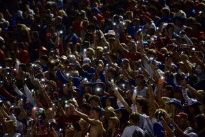 Creek students hold up their flashlights at the 2022 Homecoming varsity football game.