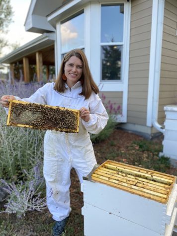 German teacher Susanne Smith poses with her beehives. Smiths grandmother kept bees to make a living after the end of World War II. She [would go] clinking down the cobblestone streets, and she would sell honey, Smith said. So beekeeping represents my family.