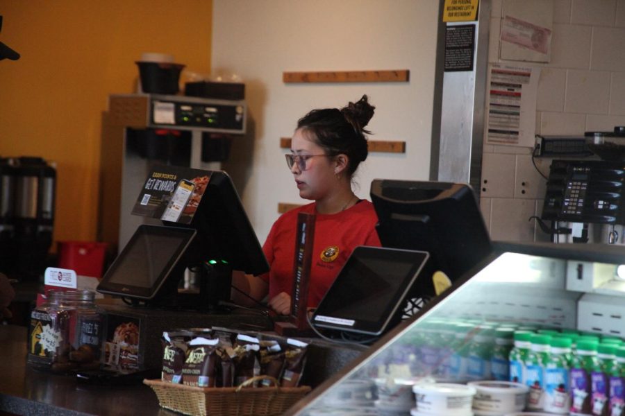 Junior+Gabby+Clark+greets+a+customer+at+the+register+of+Einstein+Bros.+Bagels+during+her+shift+on+Dec.+4.+Clark%2C+like+many+other+students%2C+works+for+a+little+extra+cash.+But+she+also+says+teens+can+be+discriminated+against+in+the+workplace.+%E2%80%9CThere+have+been+several+instances+where+schedules+have+been+changed+last+minute+for+me%2C+or+employers+assume+I+can+come+in+during+non-school+hours+when+they%E2%80%99re+short+staffed%2C+just+because+I%E2%80%99m+not+in+school%2C%E2%80%9D+she+said.