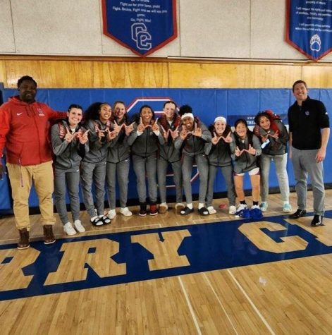 The varsity girls basketball team celebrates a win with former head coach Kent Dertinger (right), who retired early last week. The boys basketball team head coach, Klint Evans, also retired at the same time as Dertinger.