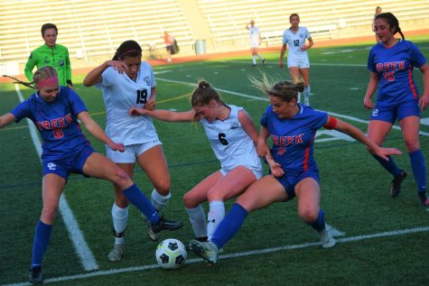 Sophomore midfielder Addison Ball (#8) and senior defenseman Nikayla Sullivan (#5) fight for control of the ball during a game against Grandview on April 18. Creek won the match 3-1.