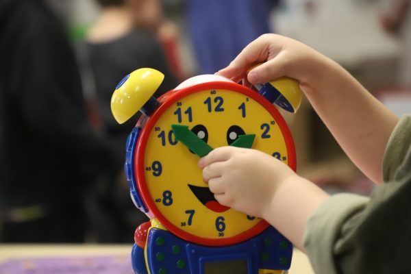 A young child plays with a toy clock in class at the Journey Preschool, a preschool involved in the UPK government-funded program.