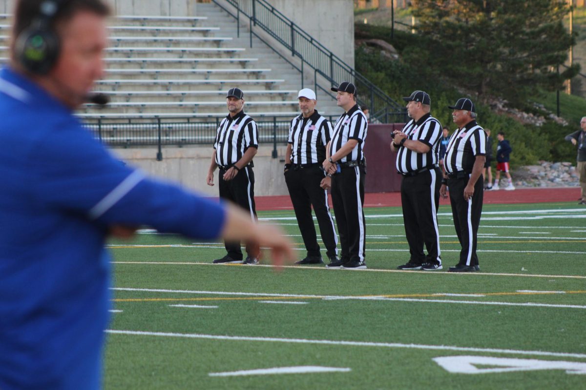 Referees discuss a play during a Creek football game against Regis on Friday, Sept. 22. Since the 2021-22 season, there have been fewer football referees as a result of early retirements. Without referees, Creek has scheduled fewer football games on Friday nights, creating issues for both players and coaches.  