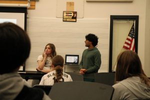 Students at the Tri-M Music Honor Society interest meeting after school on Jan. 31 watch a presentation by club president juniors Adaire Bruff (left) and Dhruv Sodani. “I hope [members] can get a connection with kids and musicians and other departments…and get this for their resume,” Sodani said.