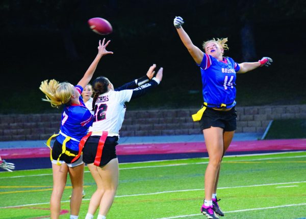 Senior Sophia Baal (#14) jumps to catch thrown by junior Addie Beck (#4) during a game against Pomona on Spet. 4