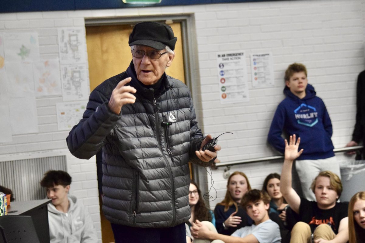 Holocaust survivor Oscar Sladek speaks to the crowd, as students raise their hands to ask him questions at the Jewish Student Connection-organized event on Jan. 27. The event started with a video detailing Sladek’s escape from the Nazis, and afterwards he answered questions from students about his experiences and what they taught him.