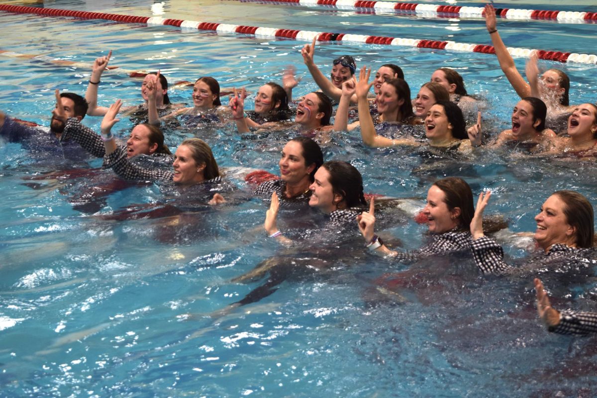 Coaches and swimmers for the girls' swim and dive team celebrate winning their fifth state championship after jumping into the water at the Veteran's Memorial Aquatic Center. 