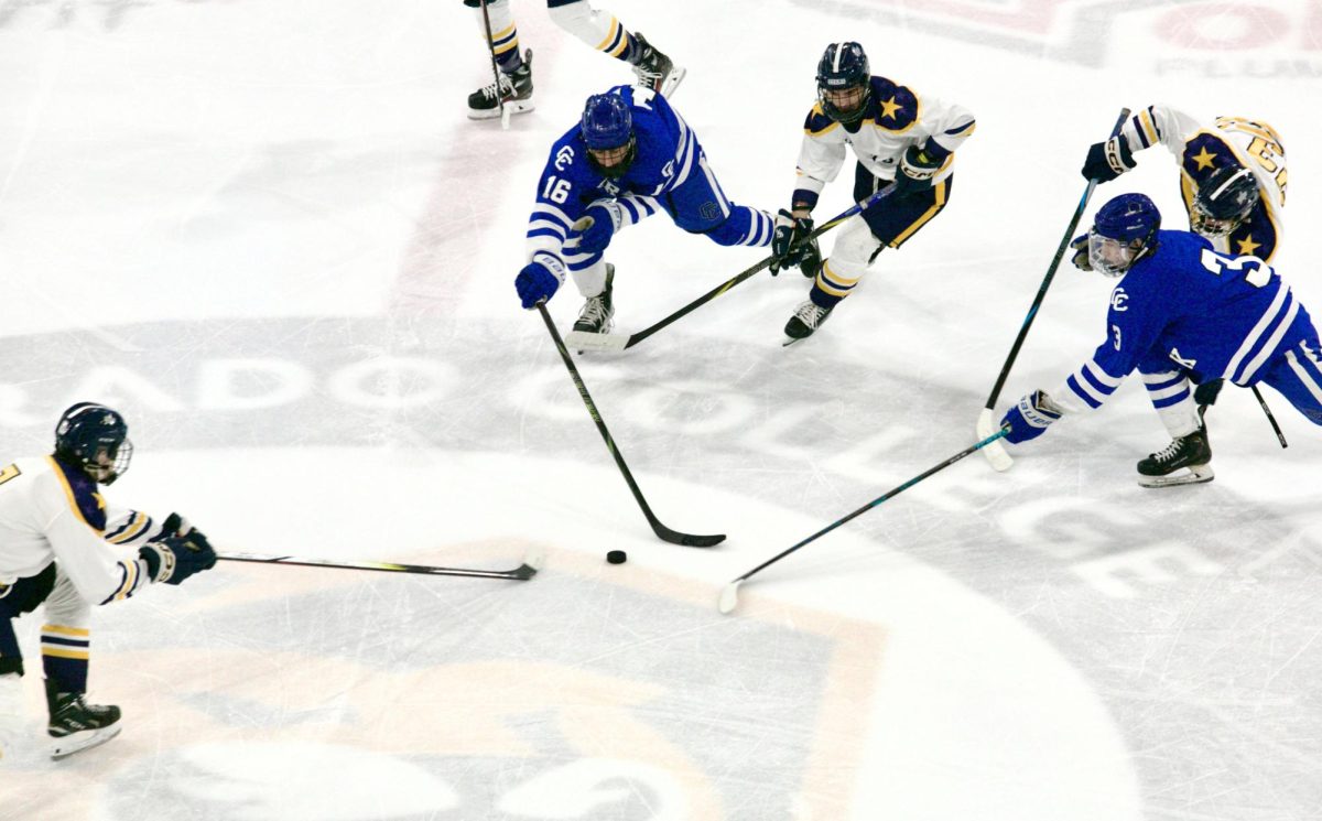 Senior attacker Logan Samador (#3) and sophomore attacker Alex Messina (#16) fight with Poudre School District players for the puck near the center of the ice. Creek wouldn’t win the March 1 matchup, their playoff run ending in the semifinals 4-3.