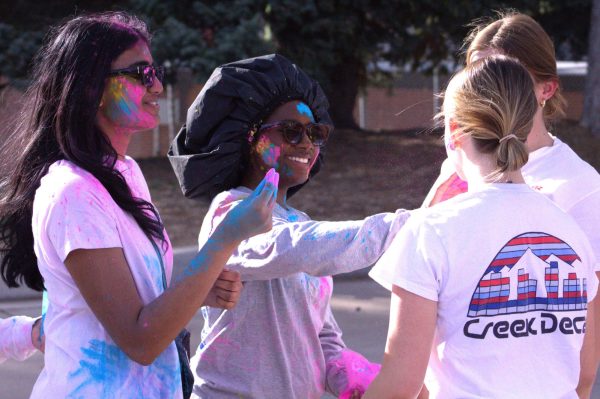 Students wipe colorful powder on each other during the Holi celebration on April 11. 