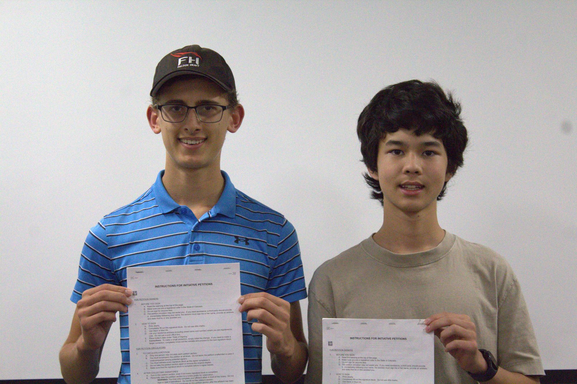 Seniors Kiran Herz (left) and Jaiden Hwang pose for a picture, legislation in hand.