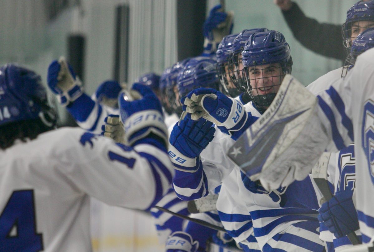 Junior forward Ari Gelfand (#9) high fives teammates after junior Austin Tucker (#14) scores a goal in a Jan. 15 matchup against Ralston Valley. 