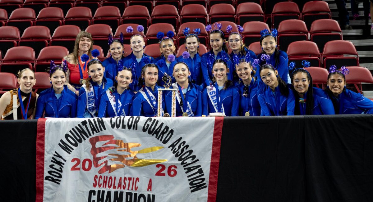 Winter guard poses with their championship trophy at Magness Arena on March 27.