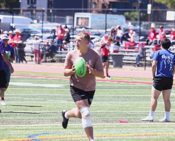 Junior Dallin Simpson primes to toss a rugby ball during warmups before the matchup against the East High School rugby club team on May 2.